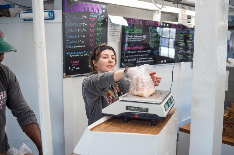 Janelle Fogg weighs out some bay scallops.