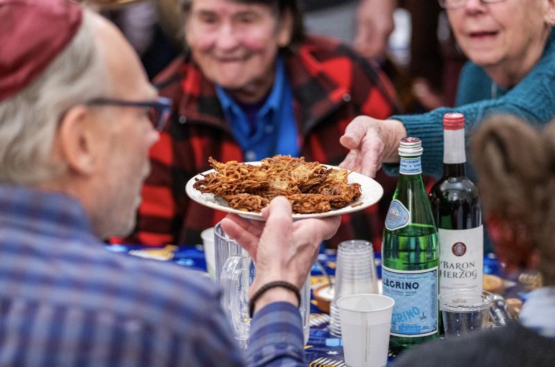 Passing around plates of latkes is a must.